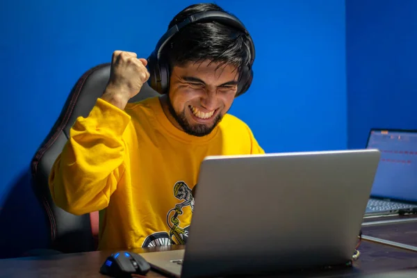 Adam evde video oyunu oynayarak zaferini kutluyor. Oyuncu ve flamalı.