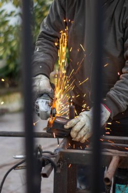 Kaynak makinesi, kaynakçı miğferi takarak ızgaraya kaynak yapıyor. Çok güzel bir kaynak flaşla.