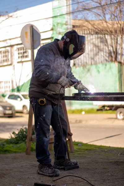Kaynak makinesi, kaynakçı miğferi takarak ızgaraya kaynak yapıyor. Çok güzel bir kaynak flaşla.