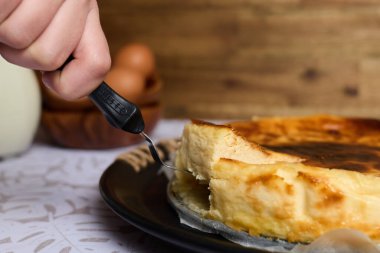 Kahverengi ve beyaz arka planda yumurta ve sütle kremalı peynirli kek.