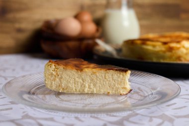 Kahverengi ve beyaz arka planda yumurta ve sütle kremalı peynirli kek.