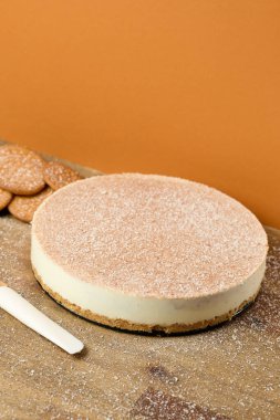 Turuncu zemin üzerinde kurabiyeler olan koyu ve beyaz çikolatalı pasta.