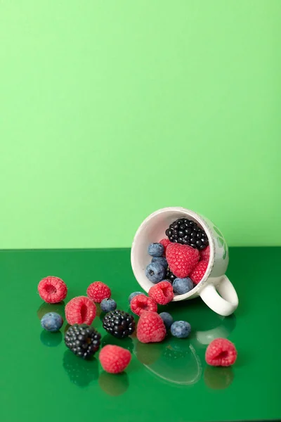 Cup Red Fruits Green Background Mirror Effect — Stock Photo, Image