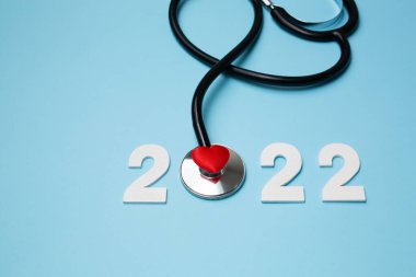 Steteskoplu 2022 ahşap numara. Kalp sağlığı ve tıbbi konsept, hayat sigortası işi ve yeni yıl kararları için mutlu yıllar.