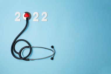 Steteskoplu 2022 ahşap numara. Kalp sağlığı ve tıbbi konsept, hayat sigortası işi ve yeni yıl kararları için mutlu yıllar. Pankart