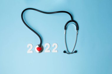 Steteskoplu 2022 ahşap numara. Kalp sağlığı ve tıbbi konsept, hayat sigortası işi ve yeni yıl kararları için mutlu yıllar.