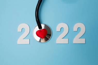 Steteskoplu 2022 ahşap numara. Kalp sağlığı ve tıbbi konsept, hayat sigortası işi ve yeni yıl kararları için mutlu yıllar.