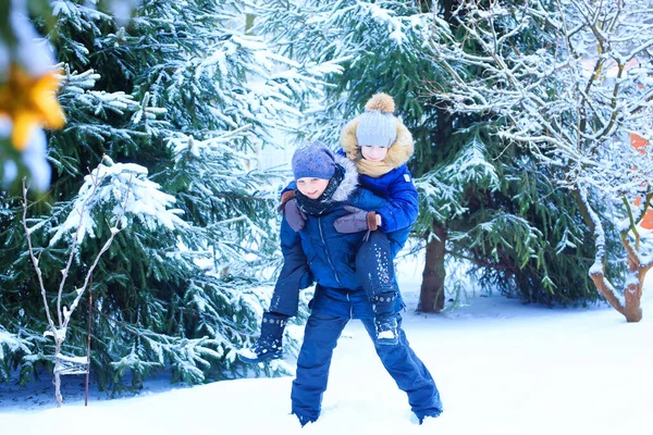 Le bambine giocano nella neve, gettano neve, cadono, si divertono, parlano e comunicano — Foto Stock