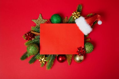 Noel ağacı dalları ve kırmızı arka plan için boş kart ve boşluk içeren dekorasyonlar. Üst Manzara. Xmas ve yeni yıl konsepti. Yüksek kalite fotoğraf