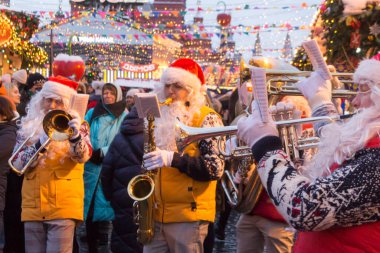 Rusya, Moskova, 19.12.2021: Kızıl Meydan, Noel Fuarı, Noel Baba kostümlü orkestra müzisyenleri festival kompozisyonları sergilediler.