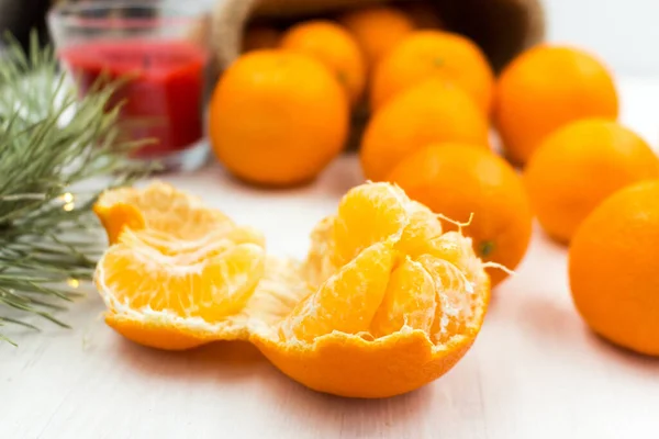 Las mandarinas perfumadas sobre la mesa de madera se acercan. Rebanadas, fruta pelada. Imagen de stock