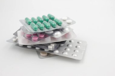 Kabarcık paketlerindeki birçok farklı tablet, beyaz arkaplanda, boşluğu kopyala.