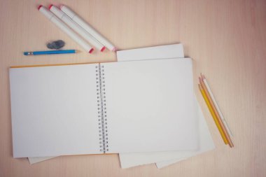 Resim malzemeleri, kalemler, renkli kalemler, estetik bir tablo içeren yüzükler üzerine bir defter.