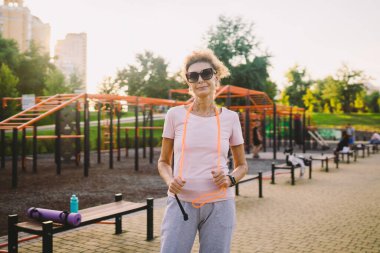 Düzenli egzersiz sağlıklı yaşam tarzının büyük bir parçasıdır. Zıplama eğitiminden sonra rahatlayan mutlu olgun bir kadın. Aktif yaşam tarzını ve sağlık hizmetlerini olgunluk çağında kavramsallaştır. Yaşlı bayan ip atlıyor..