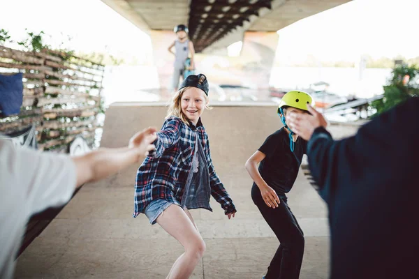 Een groep tieners op een helling in het skatepark. Kleintjes die samen plezier hebben op de sport stedelijke buitenruimte voor skateboarden. Sportclub voor kinderen. Speelse vaardigheid. Skateboardclub voor kinderen — Stockfoto