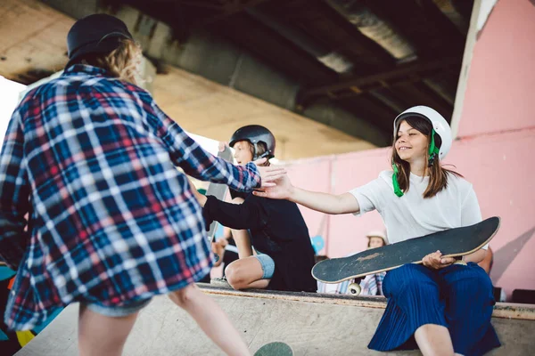 スケートパークのランプに乗って10代のグループ。スケートボードのためのスポーツ都市の屋外エリアで一緒に楽しんでいる小さなもの。子供のためのスポーツクラブ。遊び心のあるスキル。子供のためのスケートボードクラブ — ストック写真