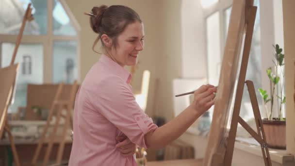 Konst, kreativitet, hobby och kreativa yrken. Att väcka kreativiteten till liv. Kvinna målning i konststudio. Attraktiv kvinnlig konstnärsmålning i verkstad. Kvinnlig hobby, verksamhet, yrke — Stockvideo