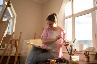 Stüdyoda çalışan kadın sanatçı. Yaratıcı çalışma alanı, resim dersi, tuval sehpası, sanat terapisi. İlham, yaratıcılık, yetenek, zanaat konsepti. Artist stüdyosu. İnsanlar, eğlence ve hobi.