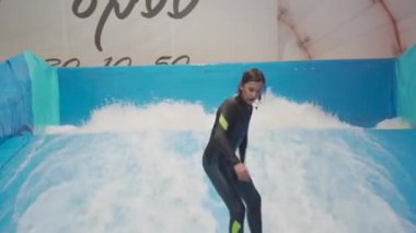 Flow Rider 'da çocuk ve eğitmen. Kapalı alanda sörf eğitimi almış. Su sörfü eğitimi alan bir genç. İçeride dalga simülatörü eğitimi alıyor. Genç sörfçü, üretilmiş dalgalar üzerine eğitim alırken. Su sporları
