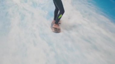 Su sporu aktivitesi, denge konsepti. Küçük sporcu ev içinde sörf yapmaktan hoşlanıyor. Gençler spor kompleksinde simülatörde dalgalarda sörf yapıyor. Sörf koçu ve öğrenci dalga simülatöründe toplandı