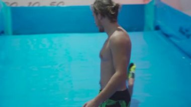 Flow Rider 'da çocuk ve eğitmen. Kapalı alanda sörf eğitimi almış. Su sörfü eğitimi alan bir genç. İçeride dalga simülatörü eğitimi alıyor. Genç sörfçü, üretilmiş dalgalar üzerine eğitim alırken. Su sporları