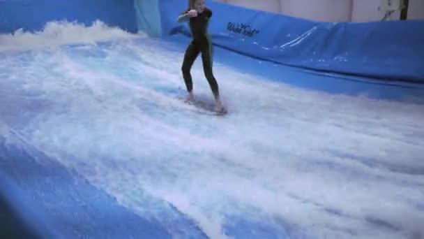 Enfant et instructeur à la séance d'entraînement de surf d'intérieur Flow Rider. Adolescent sur la formation de bord de l'eau sur la vague simulateur à l'intérieur. Jeune surfeur pendant l'entraînement sur vagues générées. Sports nautiques — Video