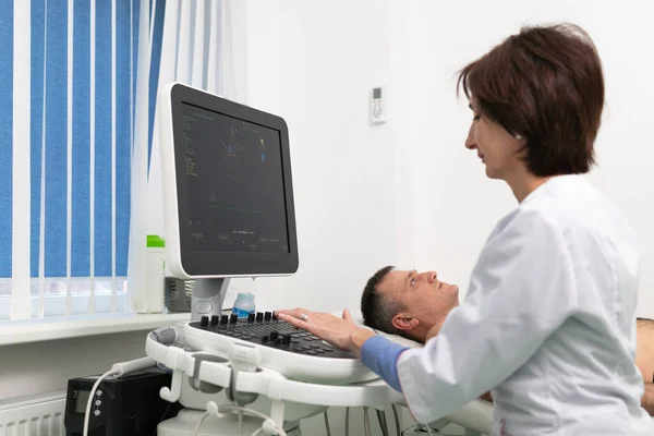 Doctor doing a doppler sonography a male patient in a cardiology clinic. Cardiologist performing an ultrasound examination at the cardiovascular hospital. Echocardiography procedure — Stock Photo, Image