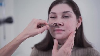 Profesyonel kadın doktor otorhinolarygologist modern hastanede otoskopla burun muayenesi yapıyor. Burun tıkanıklığı, sinüzit, alerji konsepti. Ofisteki kadın ENT doktoru ve hastası