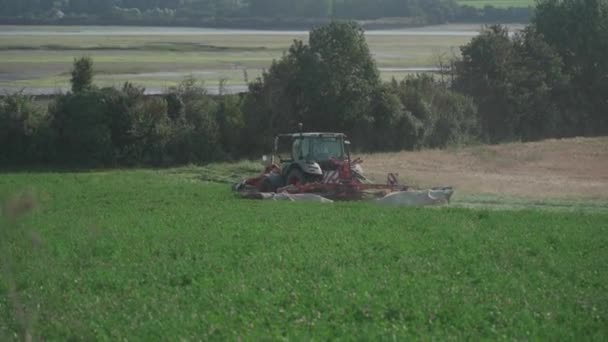 農業と農業。アグリビジネスだ。フランス、ブルターニュ地域の北の農村風景。農地の栽培、耕作と収穫、農業産業。トラクターは播種のための土地のフィールドを耕す — ストック動画