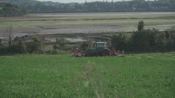 Tractor sowing crops on farm field in the north of france. Agricultural activity Brittany region, France. Tractor plowing in field. Process of growing and harvesting crops. Equipment for agriculture — Video Stock
