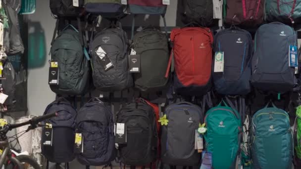 Ukraine Kiev March 19, 2021, tourist equipment and sports store. Display case with Osprey and Deuter backpacks. Variety of hiking backpacks in sports shop. Outdoor travel gear equipment — Stock Video