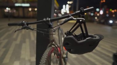 Maskeli bir bisikletçi bir bisiklet alır ve gece şehirde üzerinde kırmızı ışık olan bir kask takar. Hava kirliliği, duman ve alerjiye karşı koruyucu maskeli bir adam bisiklet kaskı takıyor.