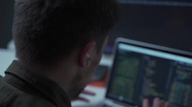Programcı bir bilgisayar başında çalışıyor ve kablosuz olarak kulağında küçük beyaz bir kulaklıkla pazarlık yapıyor. Bir bilişim yazılımı geliştiricisi bir meslektaşıyla bir proje hakkında konuşuyor.