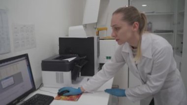 Bilimadamı kadın, laboratuarında çalışıyor, kişisel bilgisayar kullanıyor. Geliştirme, analiz ve genetik. Eczacılık Araştırma Merkezi. Mikrobiyolog laboratuardaki bilgisayardaki verileri kontrol ediyor.