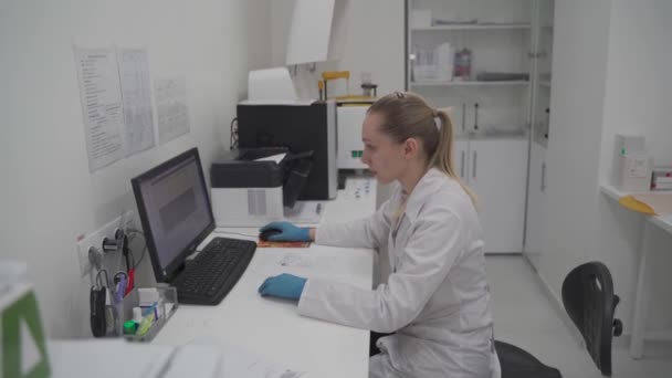 Kvinnlig forskare bioteknik som arbetar med datorforskning i utvecklingslabb. Kemisk forskningsteknik i det vetenskapliga medicinska laboratoriet utvecklar och utvecklar en ny typ av vaccin — Stockvideo