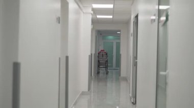 Boş sedye trolleri hastanedeki hasta hizmetleri için kaldırıma park ediyorlar. Hastane koridorunda hasta hizmetlerini bekleyen sedye trolleri ya da hasta yatakları. Acil servis koridoru.