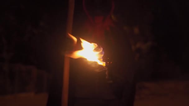 Theme is fear of death. Burning torch in hands of death with a scythe at night. Death with a scythe with a burning stick in his hands for Halloween. A man with a scythe in a suit of death with fire — Stock Video
