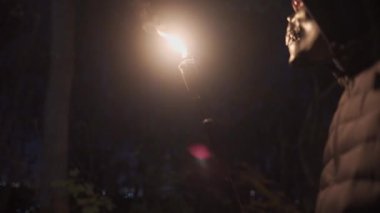 İskelet ya da ölüm maskesi takmış bir adam elinde bir meşale tutuyor ve bir Cadılar Bayramı partisinde çıkan yangına hayran kalıyor. Bambu meşaleleri. Tanımlanamayan kişi. Sopa ateş yakar