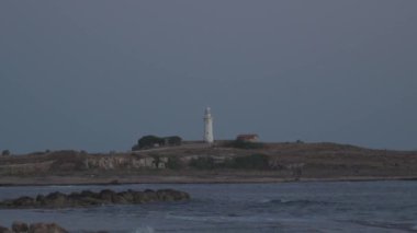 Akdeniz kıyısındaki beyaz antik deniz feneri paphos şehrinde deniz manzarası ve plajda. Akdeniz 'in şehirlerini dolaş. Kıbrıs adasında hafta sonu