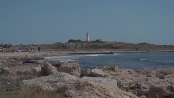 Phare dans le parc archéologique de Pafos, Chypre. point d'attraction blanc ancien phare sur la mer Méditerranée dans la ville de paphos sur l'île de cyprus vue sur la mer et la plage — Video
