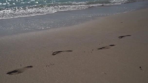 Voetsporen op zandstrand bij de oceaan. Voetafdrukken op het strand in de buurt van de Middellandse Zee in cyprus bij zonnig weer. Sporen op zand. Voetsporen op het zandstrand — Stockvideo
