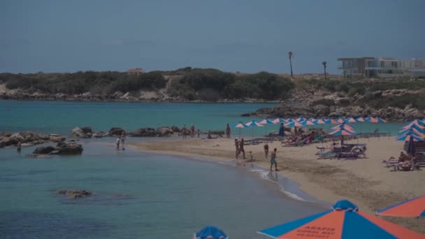 20 Mayıs 2021 Kıbrıs, Paphos. Kıbrıs 'ın paphos yakınlarındaki ünlü Coral Bay Sahili. Idyllic tropikal manzarası, kumlu plaj ve berrak gök mavisi suyla dinlenmek için. — Stok video