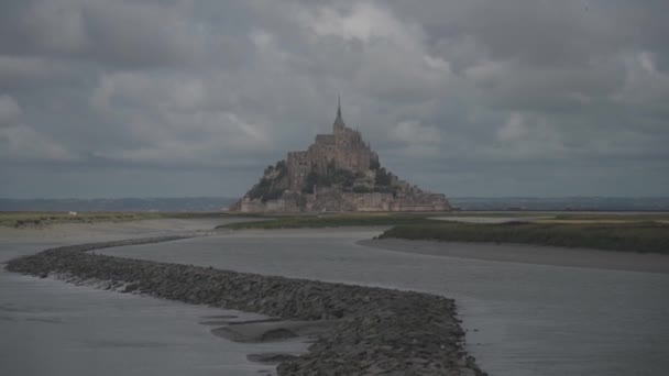 En la costa del Océano Atlántico, en la cima de una montaña rocosa que se convierte en una isla en marea alta, es la fortaleza-monasterio del Mont Saint-Michel en el norte de Francia, región de Normandía — Vídeos de Stock