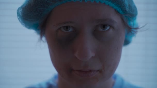 Eine verängstigte, traumatisierte Frau mit Verletzungen an Zähnen und Gesicht blickt in ihrer Krankenhauskleidung in die Kamera der Klinik — Stockvideo