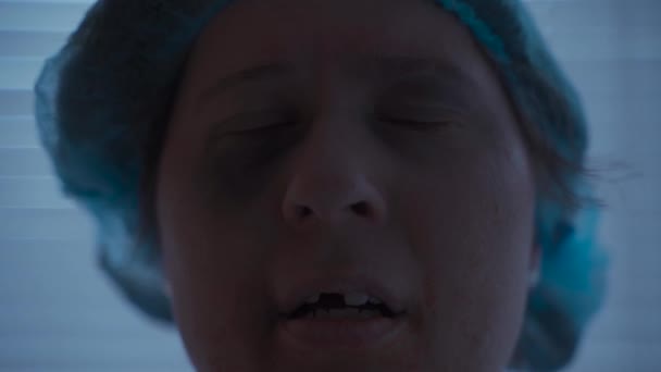 O femeie caucaziană cu traumatisme faciale și dentare și leziuni arată trist la camera din rochia ei de spital de la spital — Videoclip de stoc