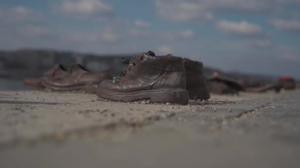 Schoenen aan de Donauoever - een gedenkteken voor de slachtoffers van de Holocaust, opgericht in 2005 aan de oever van de Donau in Boedapest — Stockvideo