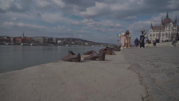 8. března 2022 Budapešť, Maďarsko. Boty na nábřeží Dunaje. Socha v Budapešti. Maďarský památník holocaustu. Evropský památník v podobě bot na břehu řeky. Pamětihodnosti Budapešti — Stock video