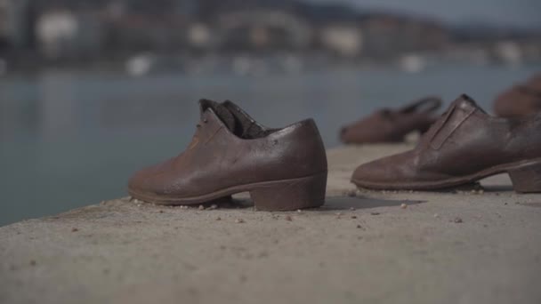 Zapatos viejos de metal oxidado en el parapeto del dique del río Danubio en Budapest, Hungría. Monumento a las víctimas de la represión nazi. El terror nazi y el Holocausto — Vídeo de stock