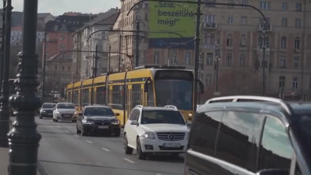 8. března2022. Maďarsko. Budapešť. Typická žlutá tramvaj projíždí hlavními ulicemi města za slunečného jarního počasí — Stock video