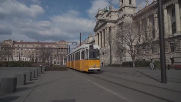 8. března 2022 Budapešť, Maďarsko. Veřejná doprava v Budapešti. Typická žlutá tramvaj projíždí starým městem v Budapešti — Stock video